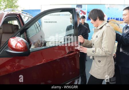 Champion de natation olympique chinoise Ye Shiwen, centre, ouvre la porte de sa BMW X5 au cours d'une cérémonie de livraison à un concessionnaire BMW à Hangzhou city, EAS Banque D'Images