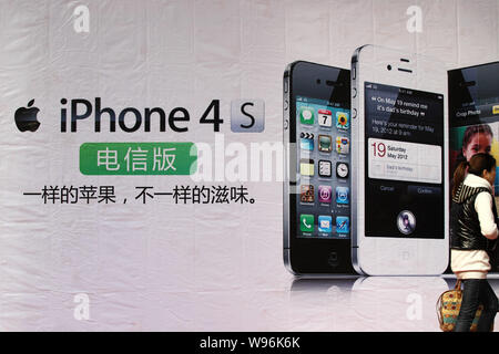 --File--un piéton passe devant une publicité pour l'iPhone 4S smartphone pour China Telecom dans Nantong ville, province de Jiangsu, Chine de l'Est, 9 mars Banque D'Images