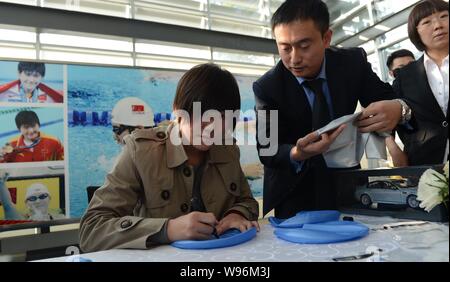 Champion de natation olympique chinoise Ye Shiwen, gauche, signe des autographes au cours d'une cérémonie de livraison à un concessionnaire BMW à Hangzhou city, east Chines Zheji Banque D'Images