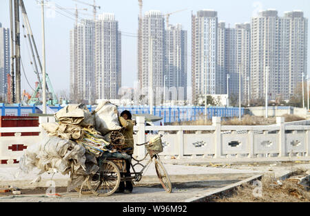 Un collecteur d'ordure charge un tricycle à près de déchets résidentiels nouveaux immeubles en construction dans la ville de Nanjing, Jiangsu, Chine orientale provinc Banque D'Images