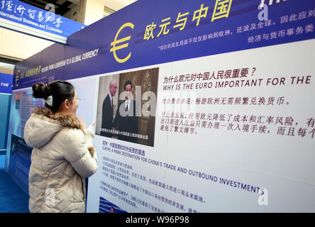 Un visiteur regarde une photo montrant le président chinois Hu Jintao serrant la main d'Herman Van Rompuy, Président du Conseil européen, au cours de l'Euro Expositio Banque D'Images