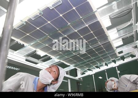 --FILE--femmes travailleurs chinois vérifier des panneaux solaires à l'usine de Shanghai Nouvelle Shenzhou Energy Development Co., Ltd. à Ganyu county, Xuzhou city Banque D'Images