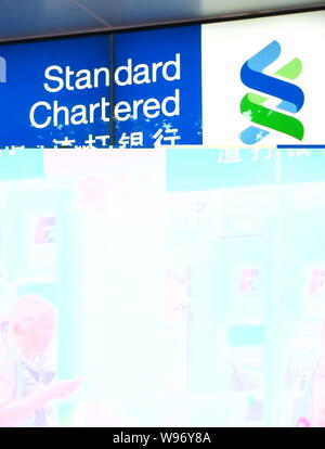 --File--une femme passe devant une succursale de Standard Chartered à Shanghai, Chine, le 26 juillet 2011. La banque britannique Standard Chartered PLC., qui dispose d'un grand Banque D'Images