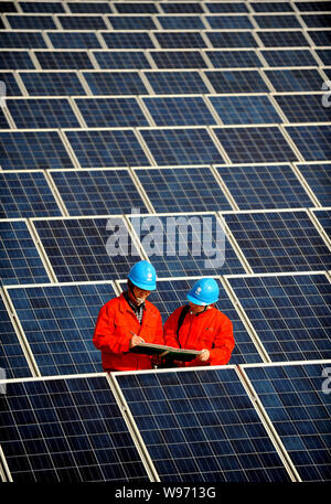 --File--travailleurs chinois vérifier les tableaux de panneaux solaires sur le toit d'un immeuble d'entreprises à Changxing county, province de Zhejiang, Chine de l'est 7 F Banque D'Images