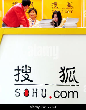 --FILE--Un employé parle chinois avec un visiteur sur le stand de Sohu.com lors d'une exposition à Shanghai, Chine, le 19 novembre 2010. Revenu net au So Banque D'Images