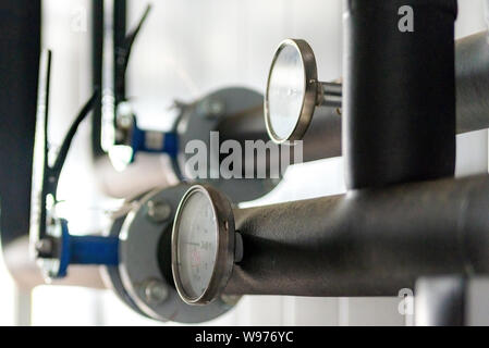 L'équipement de la chaufferie, maison - Vannes, tuyaux, manomètres, thermomètre. Close up de tuyau, manomètre, débitmètre, pompes à eau et les vannes d'h Banque D'Images