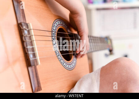 Fille apprend à jouer de la guitare pendant une leçon de musique sur l'instrument Banque D'Images