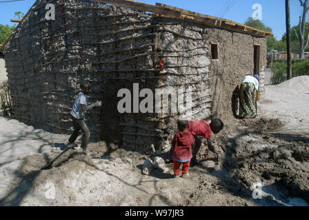 Les jeunes garçons de faire une maison de terre, Mwandi, Zambie, Afrique. Banque D'Images