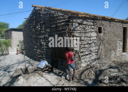 Les jeunes garçons de faire une maison de terre, Mwandi, Zambie, Afrique. Banque D'Images