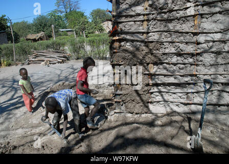 Les jeunes garçons de faire une maison de terre, Mwandi, Zambie, Afrique. Banque D'Images