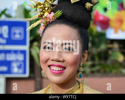 Thai girl Dressed-up avec des fleurs dans ses cheveux prend part dans le village historique de la street parade Lanna et sourit pour la photo. Banque D'Images