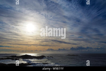 Surréaliste, mais très réel, naturellement beau ciel nuageux et voilé d'orange pâle, lever du soleil sur l'océan Pacifique au bord de la mer, Sawtell NSW Australie Banque D'Images