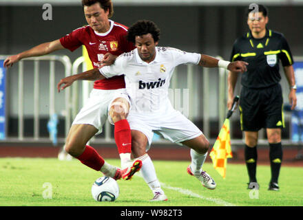 Marcelo Vieira da Silva Junior du Real Madrid, à droite, les défis de Guangzhou Evergrande Gao Lin dans un match de football amical dans la ville de Guangzhou, au sud C Banque D'Images