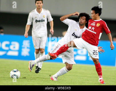 Marcelo Vieira da Silva Junior du Real Madrid, centre, défis Wu Pingfeng de Guangzhou Evergrande dans un match de football amical dans la ville de Guangzhou, de sorte Banque D'Images