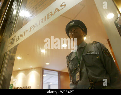 --FILE--un personnel de sécurité chinois monte la garde à l'office de BNP Paribas dans le quartier financier de Lujiazui à Pudong, Shanghai, Chine, le 21 septembre Banque D'Images