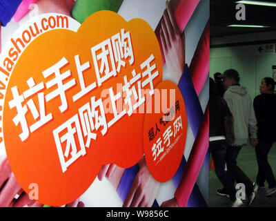 --FILE--Local des résidents chinois passe devant une publicité pour l'achat de groupe en ligne site lashou.com à Shanghai, Chine, 19 mars 2011. Le groupe chinois- Banque D'Images