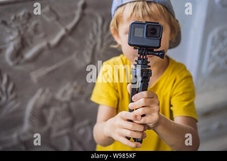 Petit garçon tire une vidéo sur un appareil photo d'action Banque D'Images