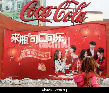 --FILE--un résident local passe devant une publicité de Coca Cola à Shanghai, Chine, 27 mars 2011. Coca-Cola Co., le plus grand fabricant de boissons gazeuses Banque D'Images