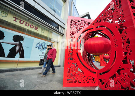 Les résidents locaux chinois passé à pied des lampions rouges et décorations d'être affichée pour la fête du printemps à venir, connu sous le nom de la Nouvelle Année lunaire chinoise, Banque D'Images