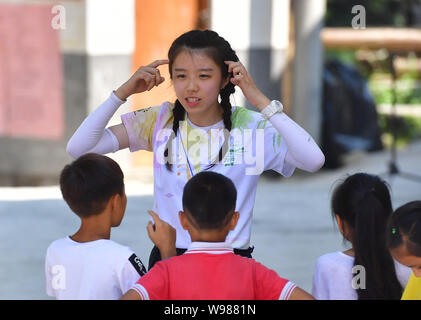 (190812) -- RONGSHUI, Août 12, 2019 (Xinhua) -- un volontaire de Macao joue un jeu avec les enfants à Wuying, un village de l'ethnie Miao dans le cadre d'une administration conjointe par Rongshui County dans la région autonome Zhuang du Guangxi et ses voisins Congjiang Comté de la province du Guizhou, au sud-ouest de la Chine, le 11 août 2019. Plus de 30 étudiants bénévoles de la Chine du sud Macao offre un service d'enseignement d'une semaine pour les enfants dans ce village éloigné. Les bénévoles préparé différentes classes dont la peinture, d'agir, de la science et de PE pour enrichir les vacances d'été pour enfants local et d'élargir leur horizon. ( Banque D'Images