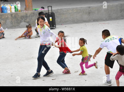 (190812) -- RONGSHUI, Août 12, 2019 (Xinhua) -- Des bénévoles de Macao et les enfants de jouer un match au Wuying, un village de l'ethnie Miao dans le cadre d'une administration conjointe par Rongshui County dans la région autonome Zhuang du Guangxi et ses voisins Congjiang Comté de la province du Guizhou, au sud-ouest de la Chine, 10 août 2019. Plus de 30 étudiants bénévoles de la Chine du sud Macao offre un service d'enseignement d'une semaine pour les enfants dans ce village éloigné. Les bénévoles préparé différentes classes dont la peinture, d'agir, de la science et de PE pour enrichir les vacances d'été pour enfants local et d'élargir leur horizon. (Xin Banque D'Images