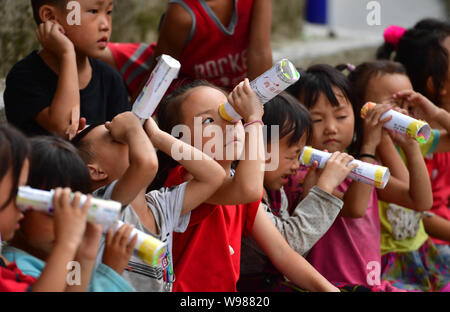 (190812) -- RONGSHUI, Août 12, 2019 (Xinhua) -- Les enfants font l'expérience de l'auto-réalisés au cours d'une classe de sciences kaléidoscopes à Wuying, un village de l'ethnie Miao dans le cadre d'une administration conjointe par Rongshui County dans la région autonome Zhuang du Guangxi et ses voisins Congjiang Comté de la province du Guizhou, au sud-ouest de la Chine, 10 août 2019. Plus de 30 étudiants bénévoles de la Chine du sud Macao offre un service d'enseignement d'une semaine pour les enfants dans ce village éloigné. Les bénévoles préparé différentes classes dont la peinture, d'agir, de la science et de PE pour enrichir les vacances d'été pour enfants local et d'élargir leurs Banque D'Images