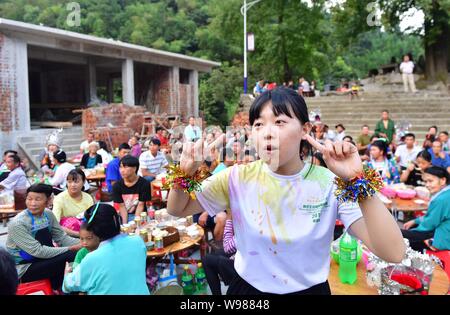 (190812) -- RONGSHUI, Août 12, 2019 (Xinhua) -- un volontaire de Macao témoigne d'un passage à des enfants lors d'une performance à Wuying, un village de l'ethnie Miao dans le cadre d'une administration conjointe par Rongshui County dans la région autonome Zhuang du Guangxi et ses voisins Congjiang Comté de la province du Guizhou, au sud-ouest de la Chine, le 11 août 2019. Plus de 30 étudiants bénévoles de la Chine du sud Macao offre un service d'enseignement d'une semaine pour les enfants dans ce village éloigné. Les bénévoles préparé différentes classes dont la peinture, d'agir, de la science et de PE pour enrichir les vacances d'été pour enfants local un Banque D'Images