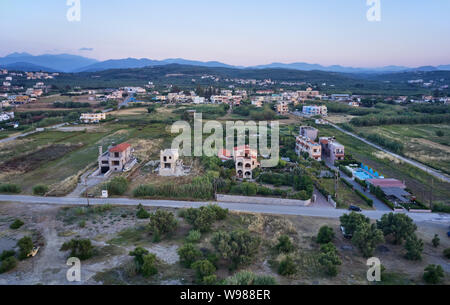 Vue aérienne du drone sur Platanias beachfront area avec villas et route à temps le soir. La préfecture de La Canée, Crète, Grèce. Banque D'Images