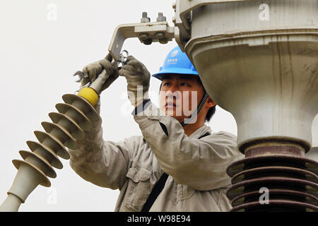 Un électricien chinois les lignes de mises à niveau, de l'est ville Maanshan Chine Anhui province, 26 mai 2011. La flambée des prix du charbon, qui alimente la plupart des Chine Banque D'Images