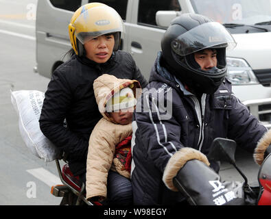 Une famille de migrants chinois conduit une moto sur une route sur le chemin de la maison pour la fête du printemps à venir, connu sous le nom de la Nouvelle Année lunaire chinoise, en zh Banque D'Images