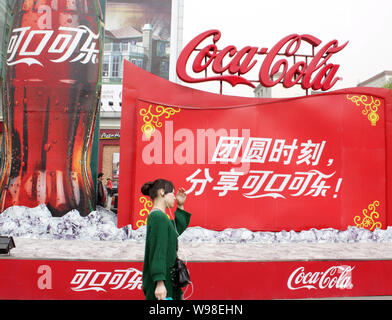 --FILE--un résident local passe devant une publicité de Coca Cola à Yichang, Chine centrale la province du Hubei, 10 février 2011. Coca-Cola Co., le monde Banque D'Images