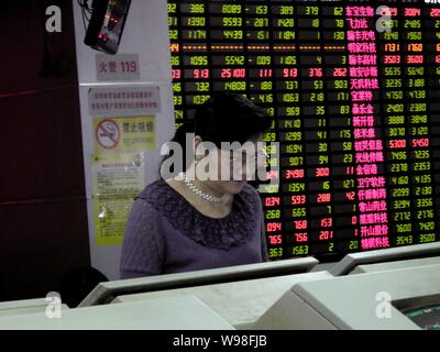 Un investisseur chinois se penche sur le prix des actions (vert pour la baisse des prix) à une maison de courtage de l'est de Hangzhou, province de Zhejiang, Chine 5 Septembre Banque D'Images