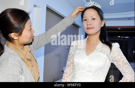 Un mannequin portant une réplique de la robe de la princesse Kate Middleton pose pour des photos dans une robe de mariage studio à Suzhou City, est de la Chine Banque D'Images