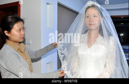 Un mannequin portant une réplique de la robe de la princesse Kate Middleton pose pour des photos dans une robe de mariage studio à Suzhou City, est de la Chine Banque D'Images