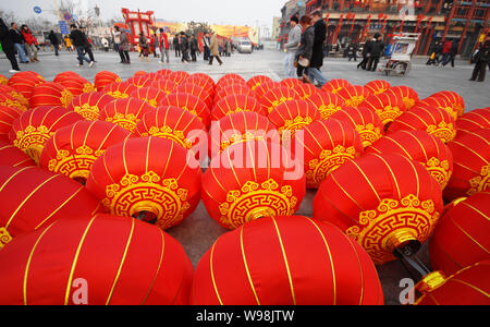 Les touristes et les résidents locaux à pied passé lampions rouges pour être suspendus le long de la rue Qianmen pour le Festival à Beijing, Chine, 15 février 2011. Banque D'Images