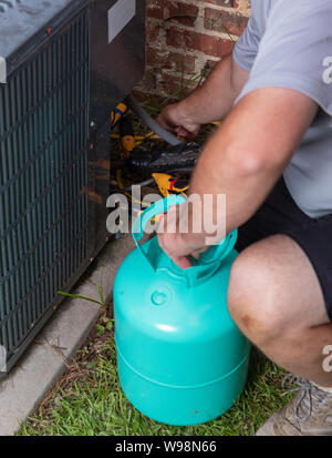 Technicien de maintenance d'air Conditioenr ajoutant refrigerent Banque D'Images