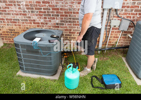 Technicien de maintenance d'air Conditioenr ajoutant refrigerent Banque D'Images