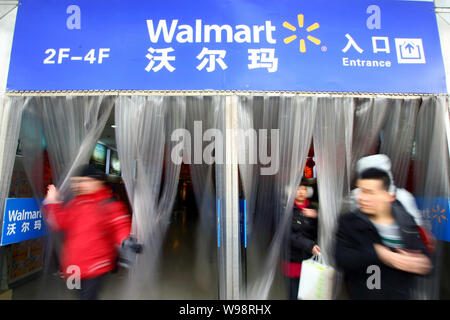 --FILE--Chinese shoppers à pied à partir d'un supermarché Walmart à Shanghai, Chine, le 27 janvier 2011. Wal-Mart Stores Inc., les mondes plus grand détaillant, Banque D'Images
