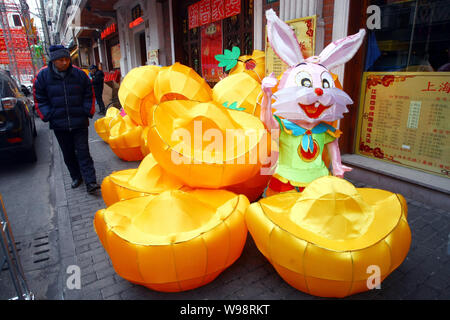 Les résidents locaux chinois devant une lanterne en forme de lapin est affiché à l'extérieur d'un restaurant pour la fête du printemps à venir, connu comme les Chinois Banque D'Images