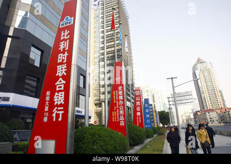 --FILE--Local des résidents chinois passent devant les enseignes, des affaires et des sociétés chinoises dans le quartier financier de Lujiazui à Pudong, Shanghai, Chine, 2 Banque D'Images