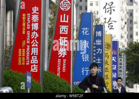 --FILE--Local des résidents chinois passent devant les enseignes, des affaires et des sociétés chinoises dans le quartier financier de Lujiazui à Pudong, Shanghai, Chine, 2 Banque D'Images