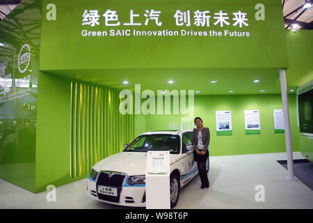 Une femme se trouve à côté d'une voiture électrique SAIC lors d'une auto show à Shanghai, Chine, le 9 novembre 2010. SAIC Motor, Chinas top auto bouilloire, prévoit d'inv Banque D'Images