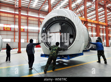 --FILE--travailleurs palan une éolienne à une usine dans la ville de Binzhou Zouping, ville de l'Est, la province de Shandong, Chine, 16 mars 2011. La Chine a accepté de s Banque D'Images