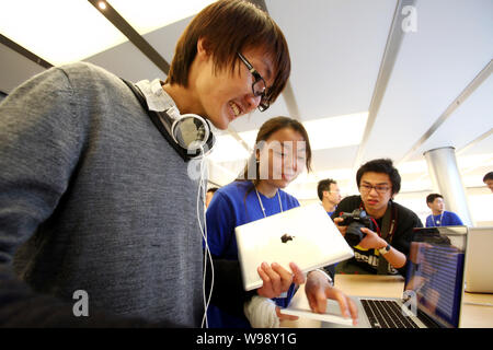 Un personnel chinois sert le premier acheteur de l'iPad 2 dans un Apple Store dans le quartier financier de Lujiazui à Pudong, Shanghai, Chine, le 6 mai 2011. Ap Banque D'Images