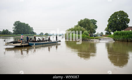 Leer, Allemagne. 11 juillet, 2019. Une vue de la gare maritime à la main 'Pünte", qui est tiré d'une banque à l'autre par deux ferrymen sur la rivière "Jümme' avec leurs mains sur une corde. Grâce à la puissance des marées et des muscles forts, un petit traversier traverse la rivière Jümme en Frise orientale. Credit : Mohssen Assanimoghaddam/dpa/Alamy Live News Banque D'Images