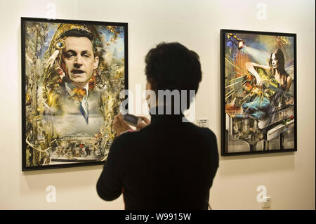 Un visiteur prend des photos d'un portrait de Nicolas Sarkozy à une exposition d'art présentant les œuvres de Pal Sarkozy, père du président français Nicolas Sa Banque D'Images