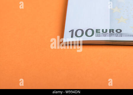 Les espèces en euros sur un fond orange et rose. Billets en euro de l'argent. Euro Argent. Euro bill. Place pour le texte Banque D'Images