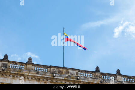 Jaune, Bleu et rouge striped drapeau colombien vole au-dessus d'un bâtiment public à Bogotá, Colombie sur une journée ensoleillée Banque D'Images