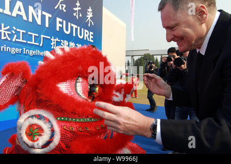 M. David Preston, président de Boehringer Ingelheim France, points les yeux d'une tête de lion au cours de la cérémonie de Boehringer Ingelheim Zhang Banque D'Images