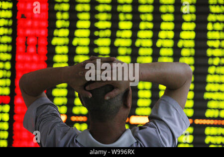 Un investisseur chinois se penche sur le prix des actions (rouge pour l'augmentation des prix et la baisse des prix vert) à une maison de courtage à Huaibei ville, East Chines Un Banque D'Images